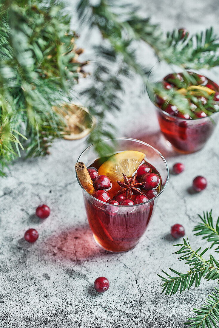 From above of glasses with cranberries with lemon next to Christmas decoration