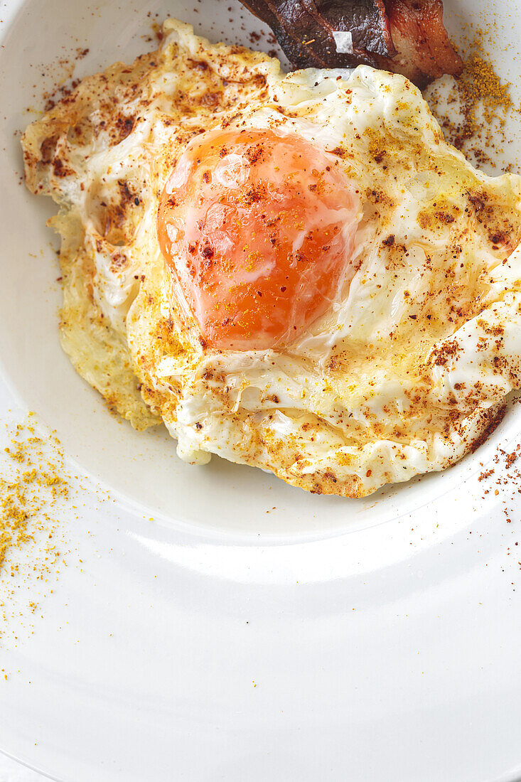 Draufsicht auf leckere Eier mit gebratenen Speckstreifen auf einem Teller
