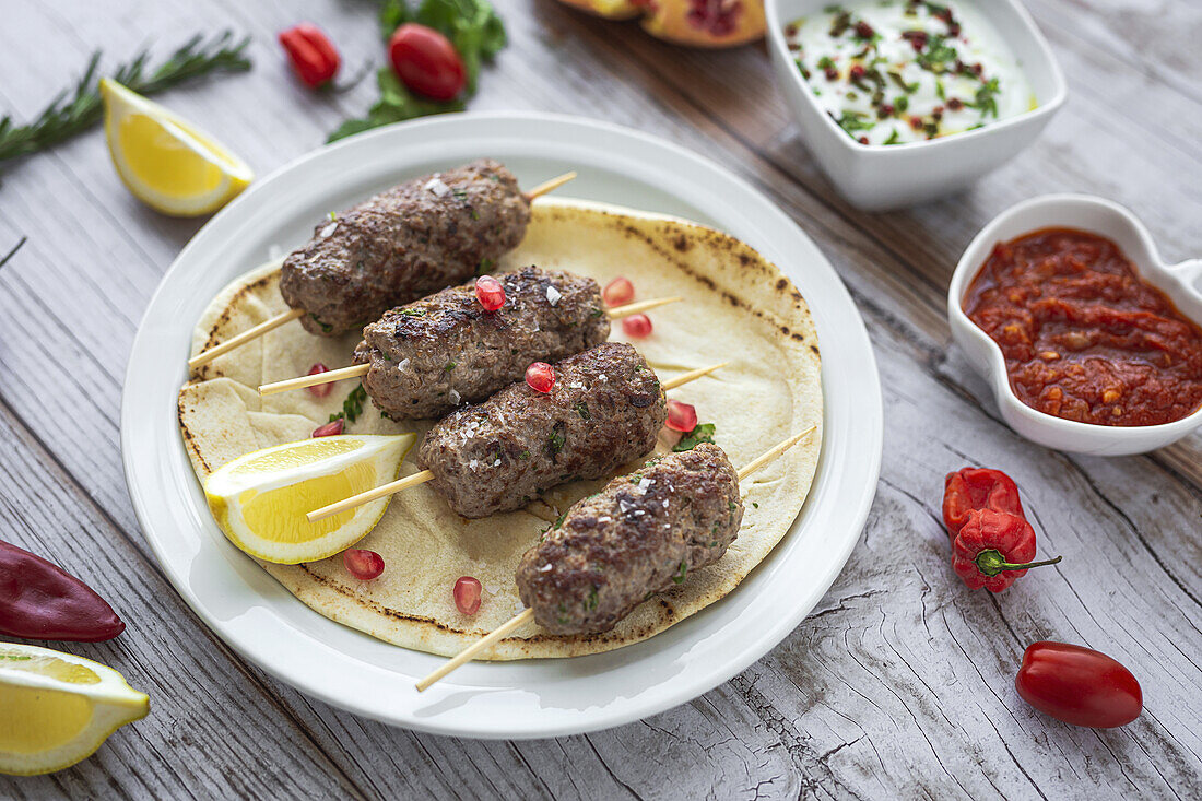 Traditional homemade kafta or kofta kebab beef and lamb with tomato sauce and yoghurt. Traditional Arabic and Turkish food. Halal food