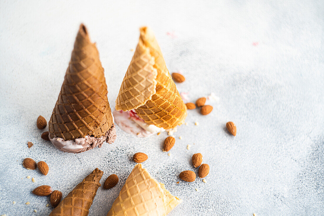 Upside down waffle cones with ice cream on concrete background