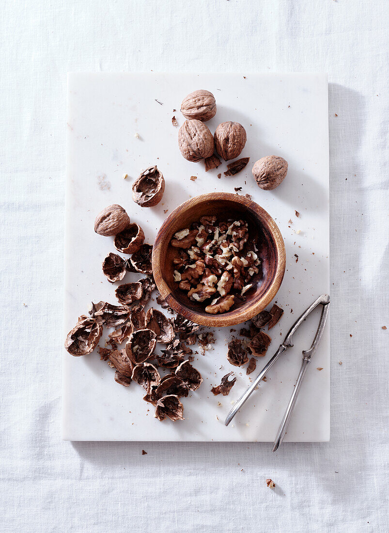 Opening walnuts with a cracker top view. White background