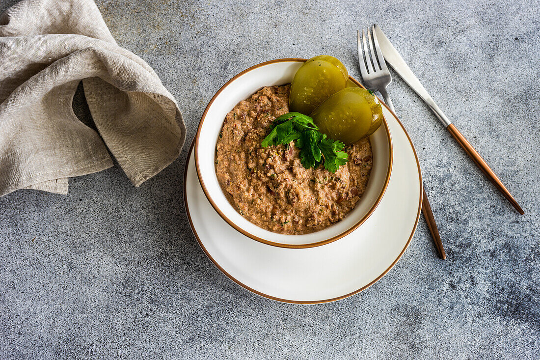 Vegetarische Bohnensuppe, serviert in einer Keramikschale mit Zwiebel und Korianderkraut