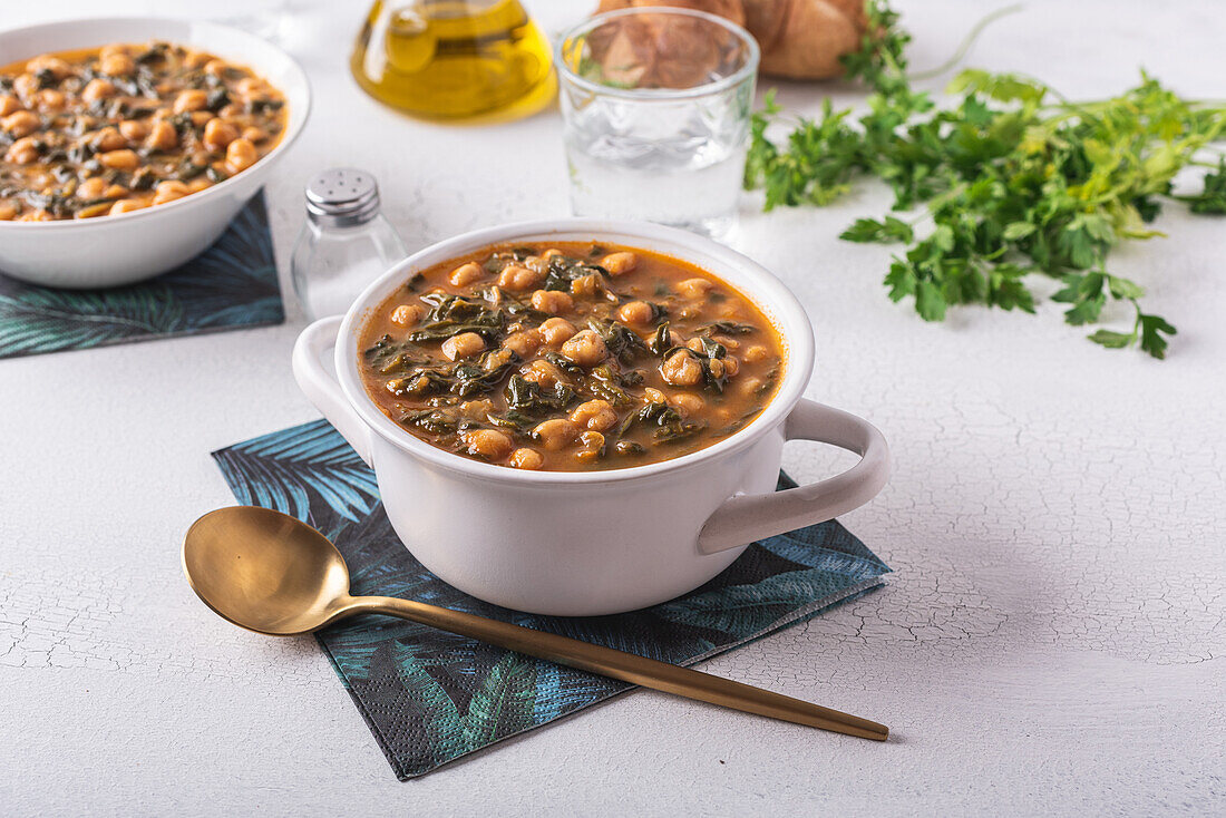 High angle of bowl with tasty chickpea soup served for lunch on paper napkin near spoon