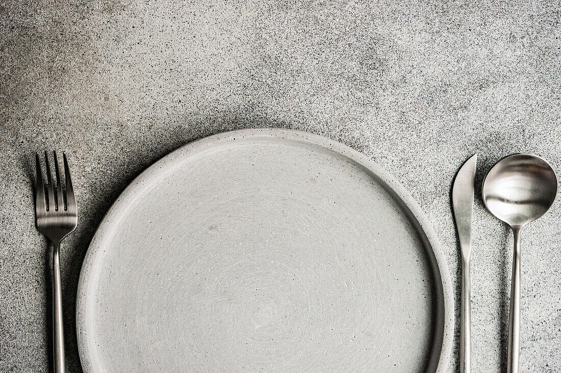 Minimalistic grey monochrome dinner set with plate and cutlery