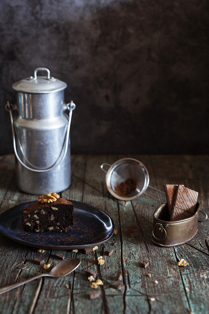 Detail of Piece of brownie cake with walnuts on a dish on wood background