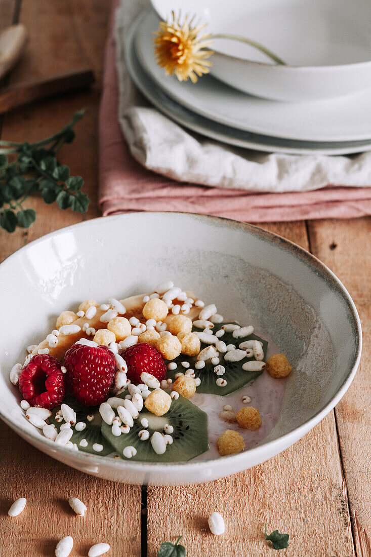 Bowl with fresh fruits and berries over rustic wooden table