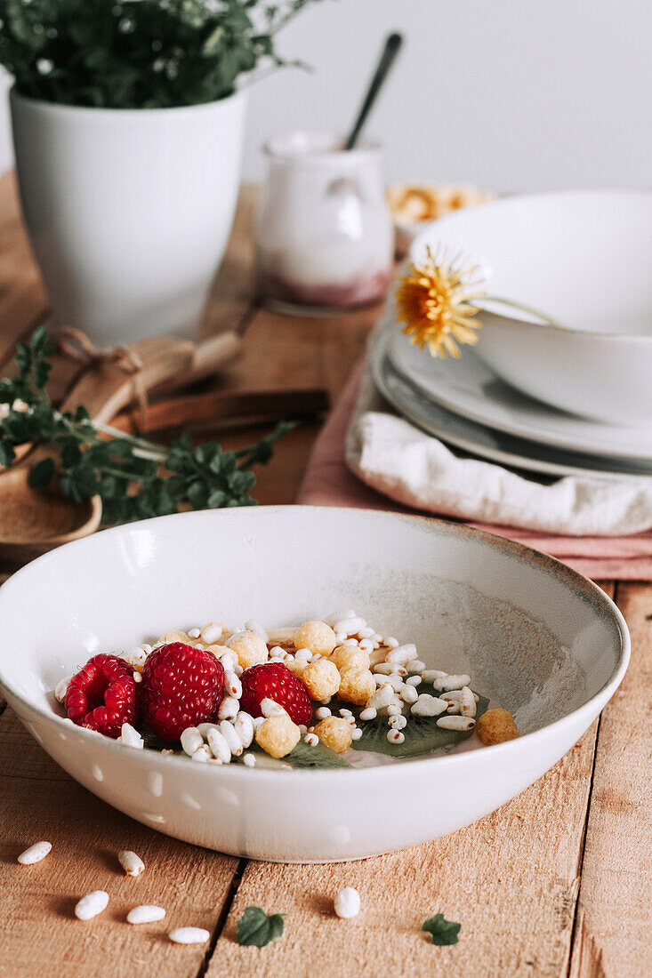 Schale mit frischen Früchten und Beeren auf rustikalem Holztisch