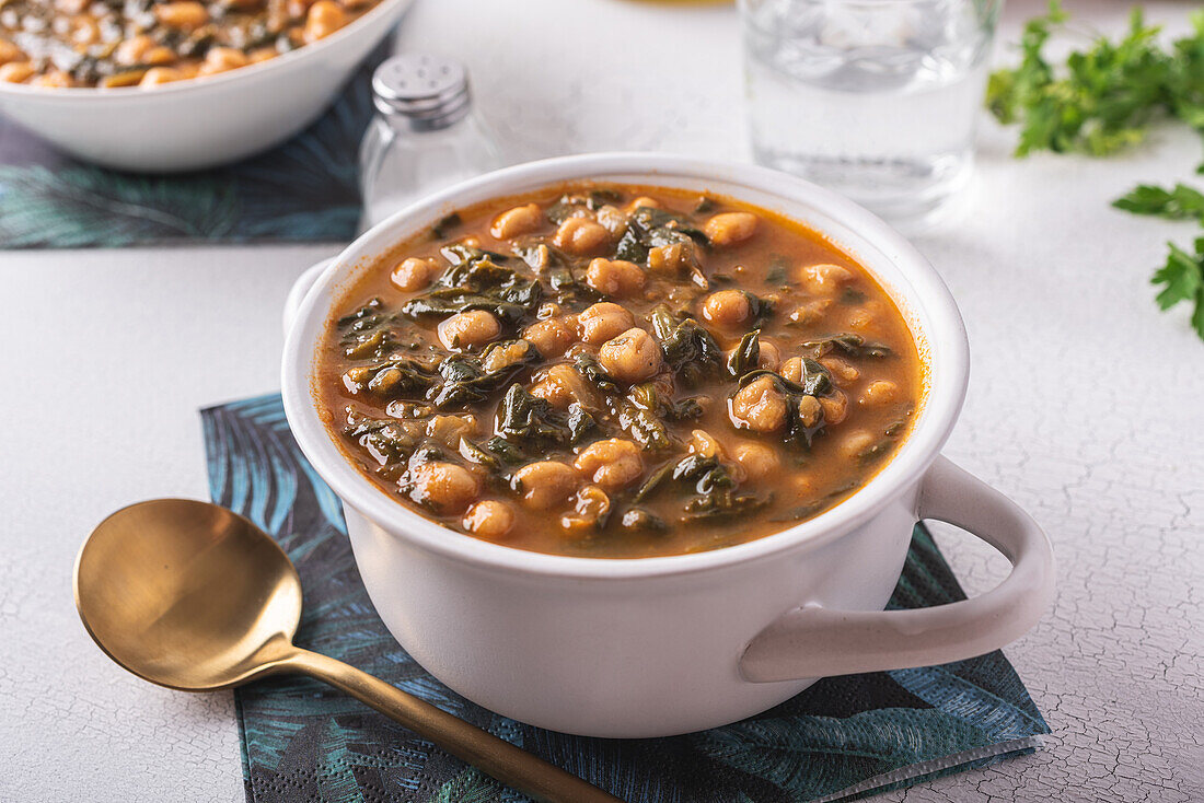 Schale mit leckerer Kichererbsensuppe zum Mittagessen auf Papierserviette neben Löffel