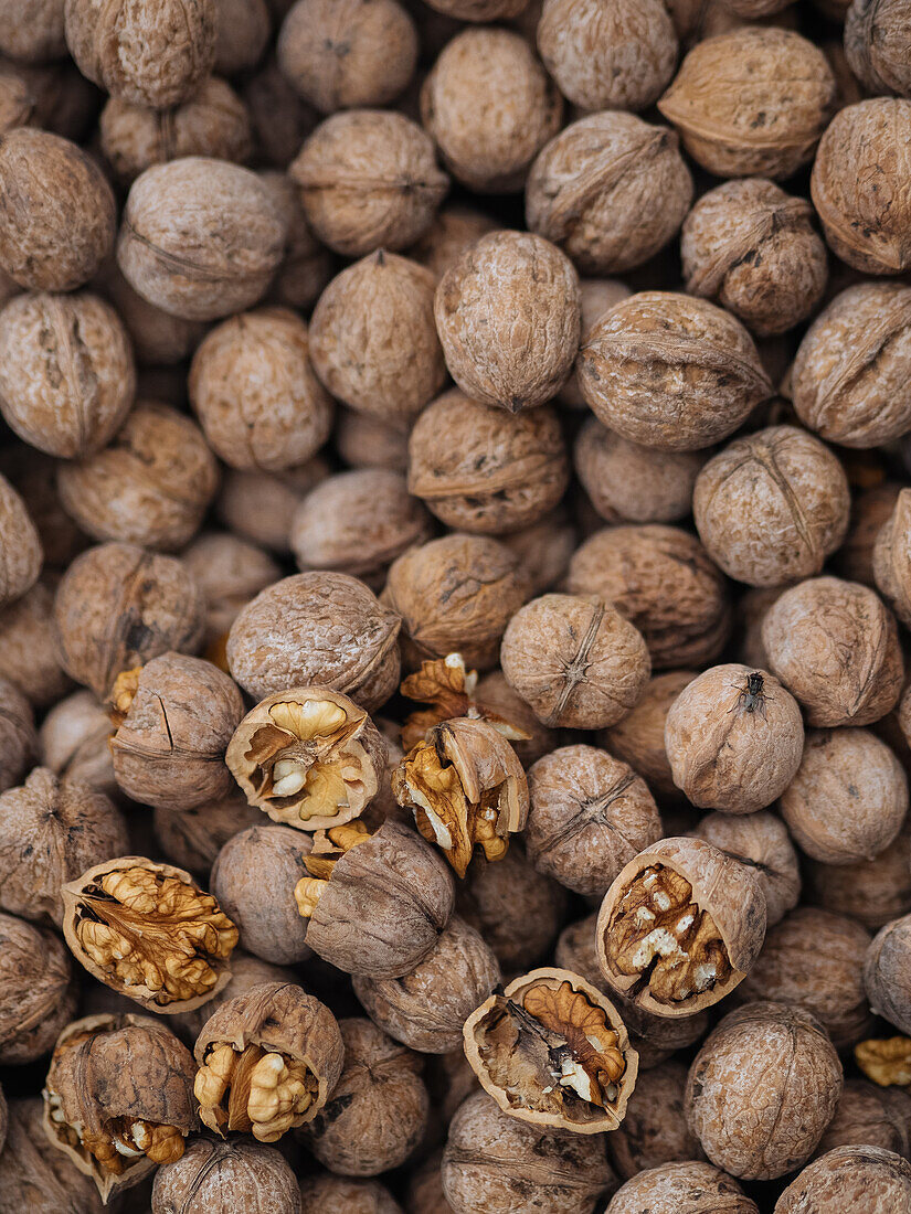 Full frame background of pile with unpeeled walnuts placed on heap in local market