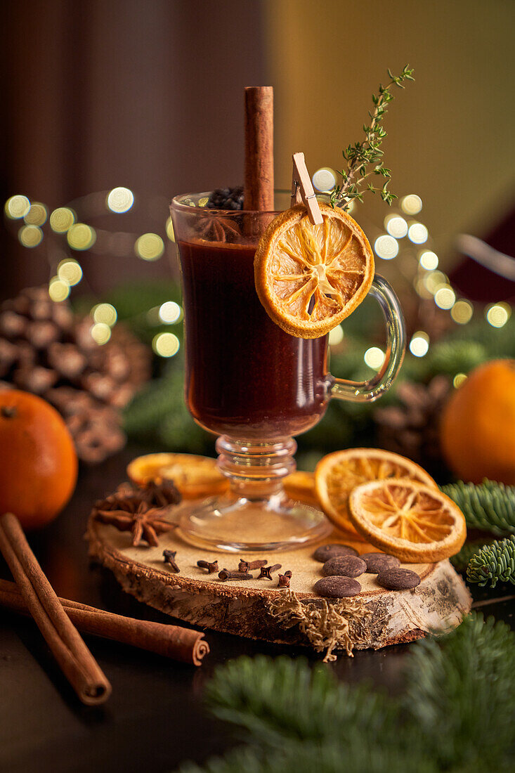 Glühwein oder Weihnachtspunsch, serviert in einem Glasbecher mit getrockneten Orangenscheiben