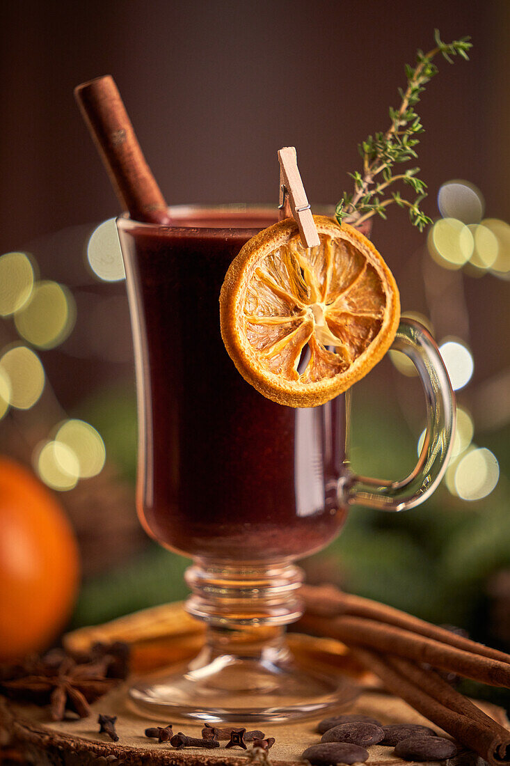 Gluhwein or christmas punch mulled wine server on a glass mug with dried orange slices