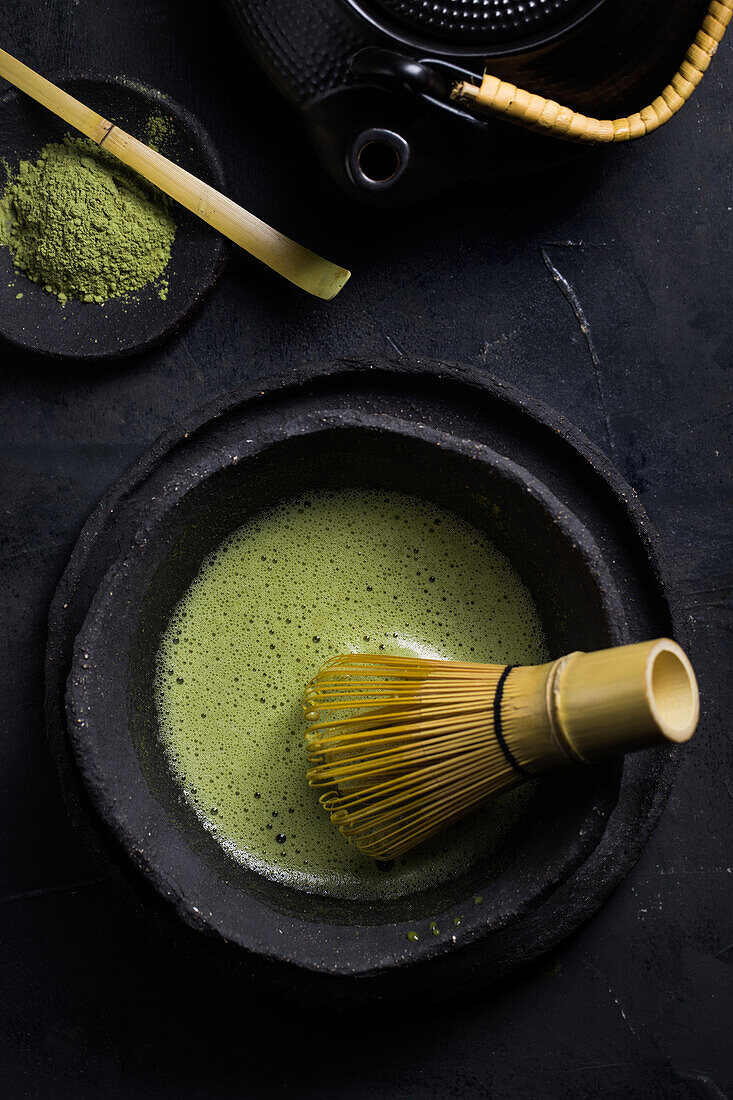 From above of traditional Japanese matcha with tea whisk in stone bowl for traditional oriental ceremony