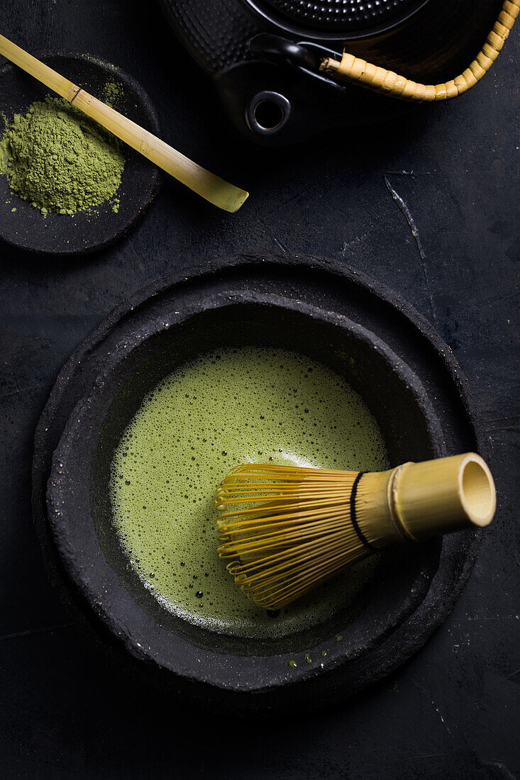 Von oben gesehen traditioneller japanischer Matcha mit Teebesen in einer Steinschale für eine traditionelle orientalische Zeremonie