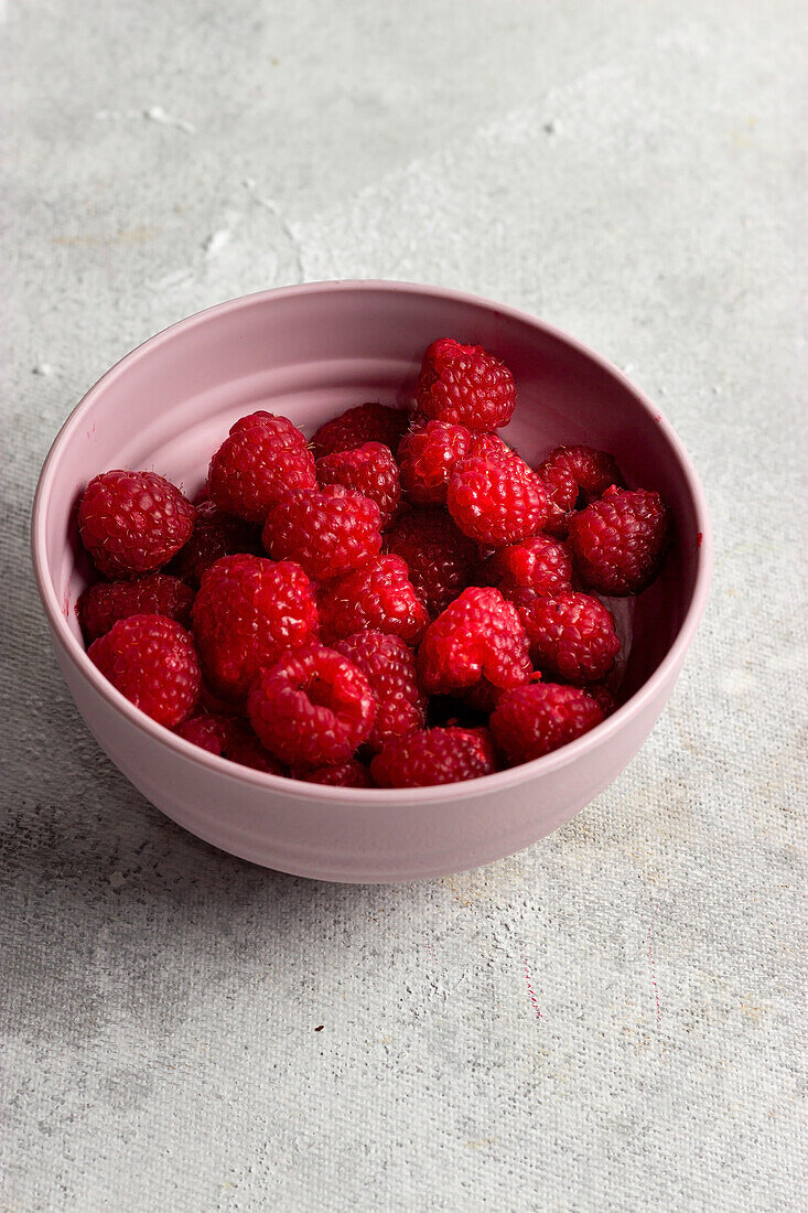 From above bowl with ripe strawberry placed on tabletop