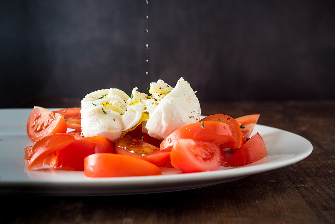 Reife Tomatenscheiben und Mozzarellakäse auf weißem Teller serviert