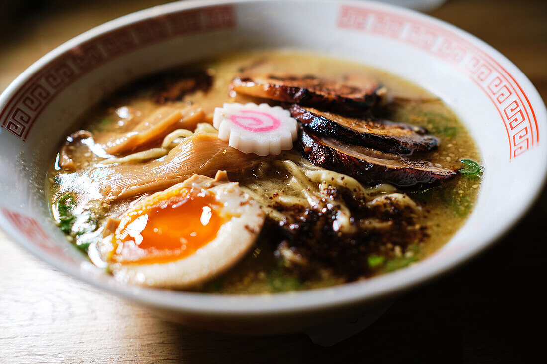 Stock photo of yummy ramen soup with boiled egg and mushrooms in japanese restaurant.
