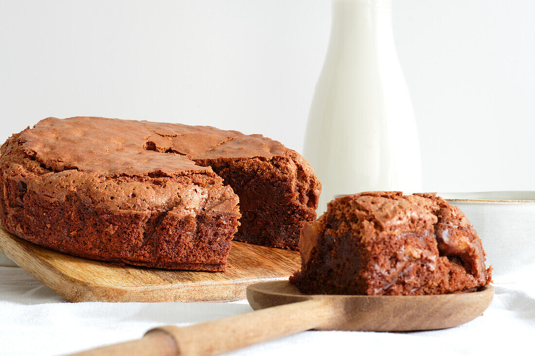 Süßer Schokoladen-Brownie-Kuchen, serviert auf einem hölzernen Schneidebrett auf einem Tisch zu Hause