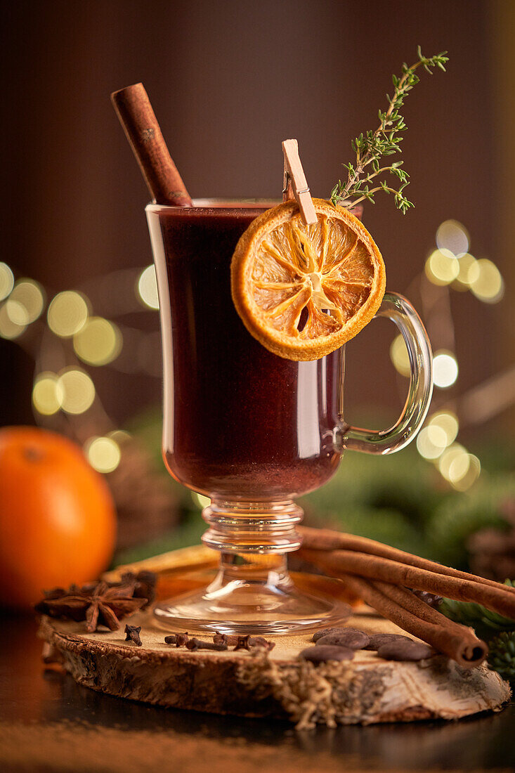 Glühwein oder Weihnachtspunsch, serviert in einem Glasbecher mit getrockneten Orangenscheiben