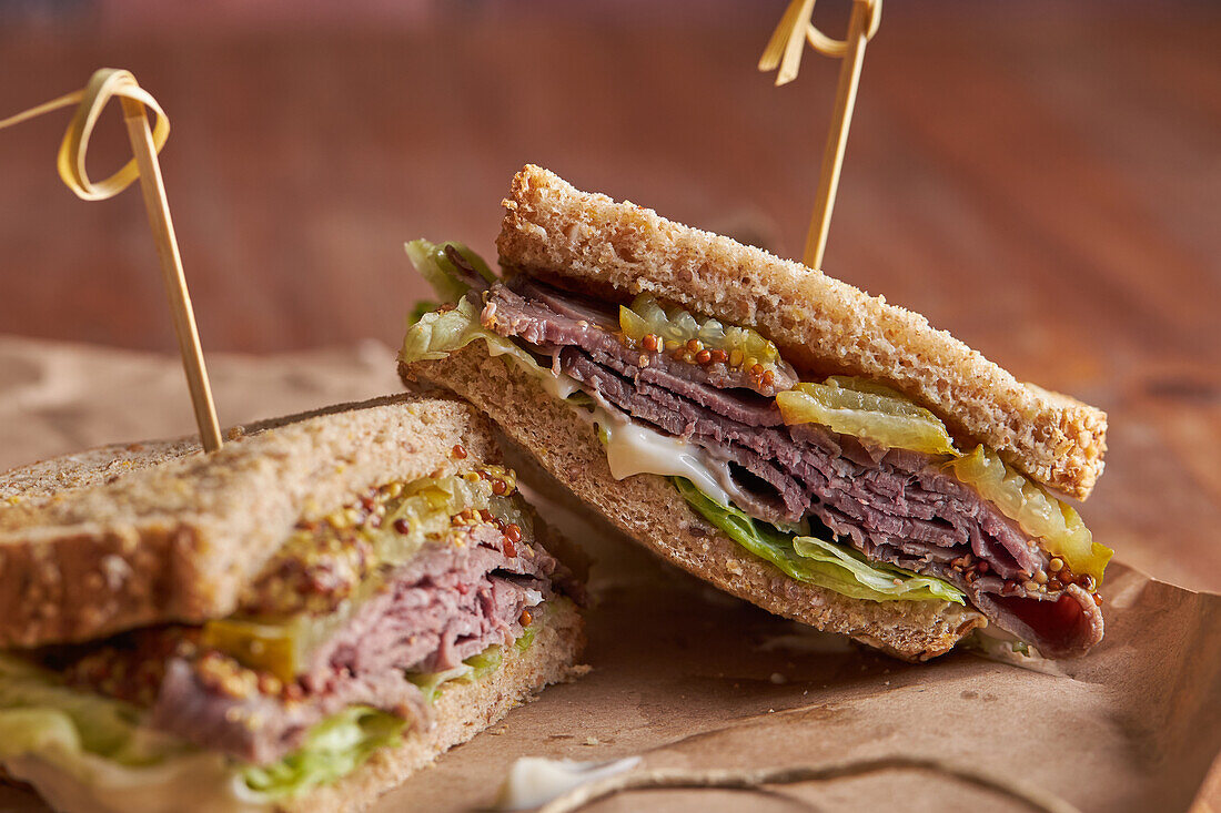 Closeup of a delicious pastrami, lettuce, ham and pickle sandwich