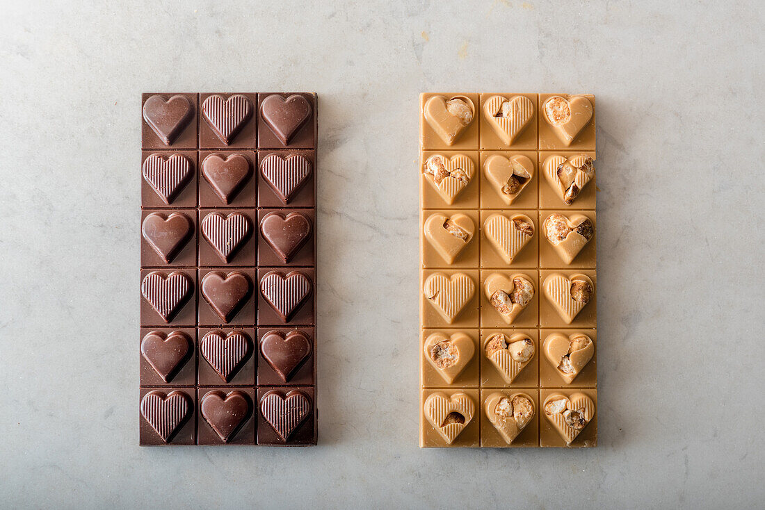 Top view of delicious chocolate candies with nuts in shape of heart on white background