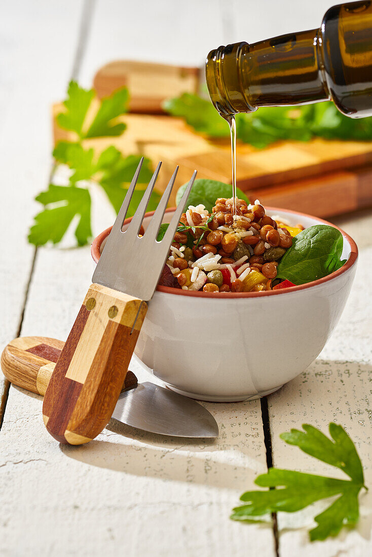 Von oben gesehen appetitliche bunte Gemüsemischung mit Spinat, Linsen und Reis auf Holzuntergrund