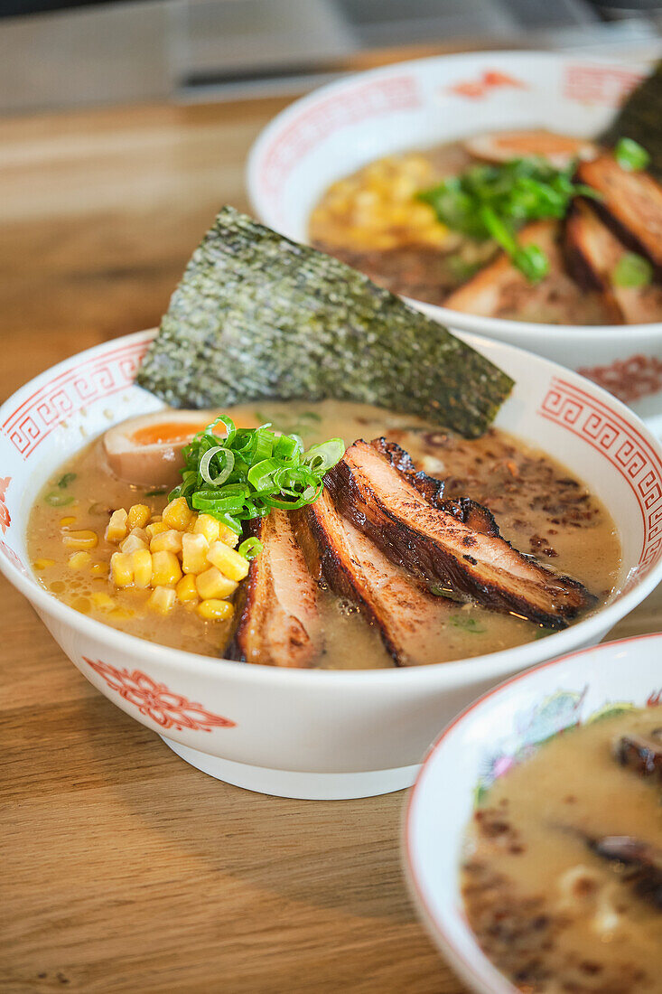 Stock photo of yummy ramen soups with boiled egg and meat in japanese restaurant ready to be served.