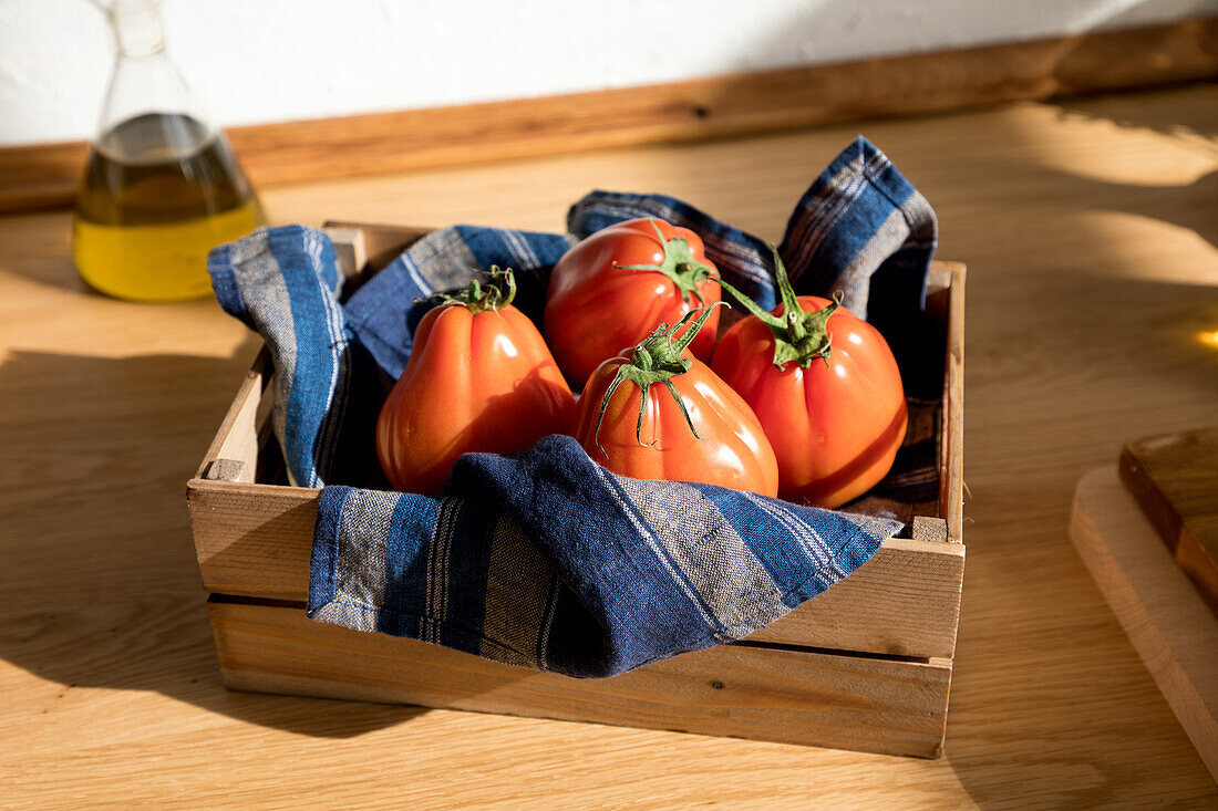 Hohe Winkel von frischen reifen roten Tomaten auf natürlichen Holztablett mit Serviette in der Küche zu Hause platziert