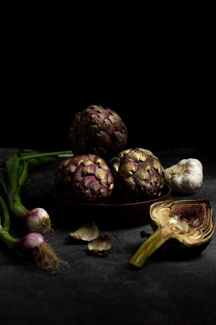 From above ripe green artichokes placed on black table background