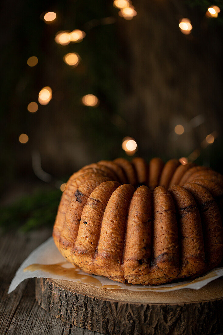 Köstlicher hausgemachter Schokoladenkuchen auf einem Holztablett vor schwarzem Hintergrund mit Lichterketten