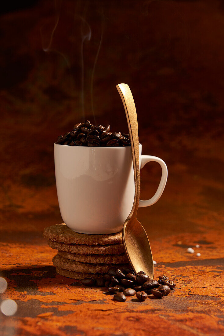 Ceramic mug of hot coffee bean spoon place on surface near pile of fresh baked oatmeal cookies