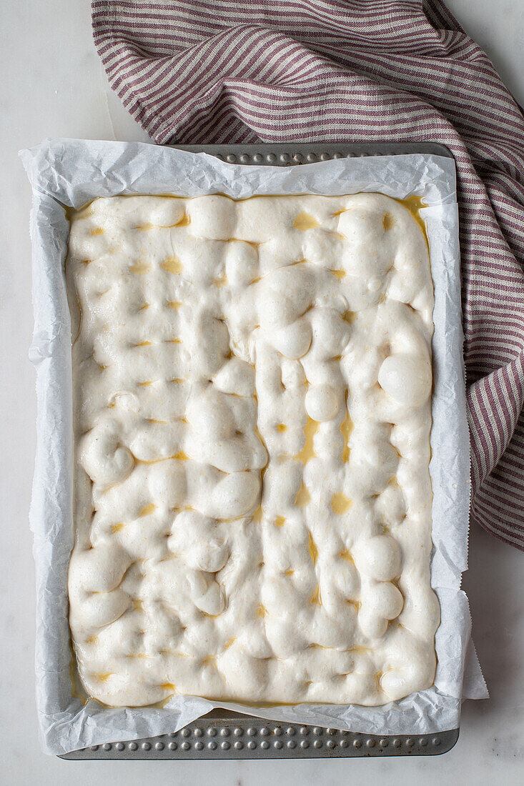 Top view of homemade dough placed on baking paper for cooking traditional bread