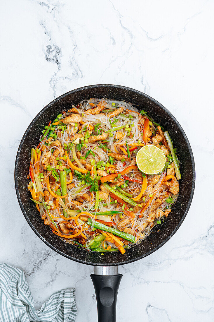 From above tasty stir fry rice noodles with vegetables served in frying pan