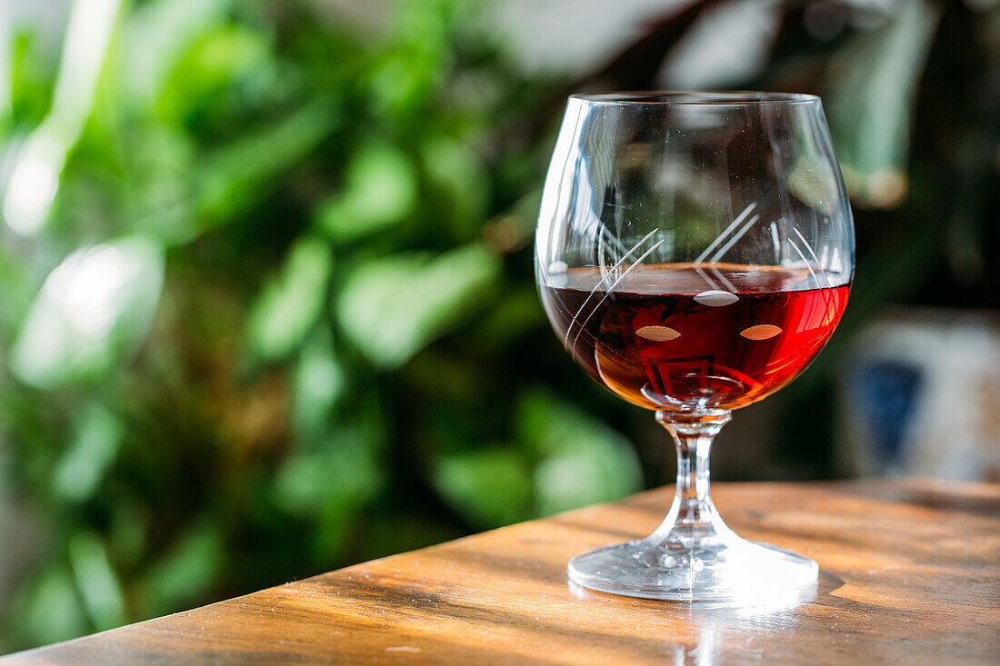 Altmodisches Cognacglas auf Holztisch mit natürlichem Licht