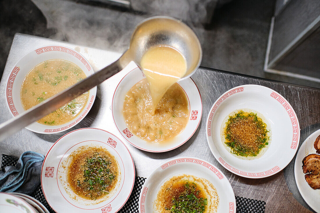 Stockfoto eines unbekannten Kochs in einem japanischen Restaurant, der Nudelsuppe serviert