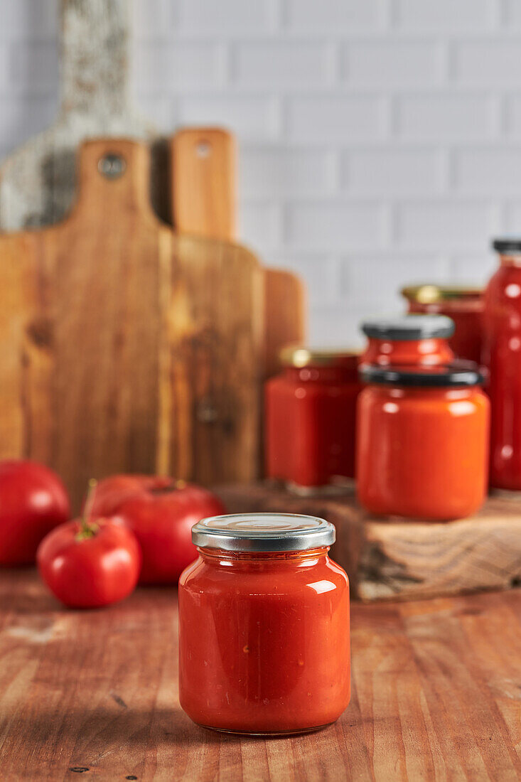 Verschlossenes Glas mit handgemachter Tomatensauce auf dem Tisch in der Küche zu Hause