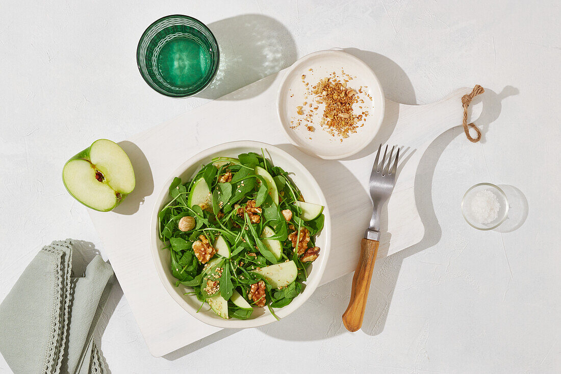 Von oben leckerer grüner Apfel, Fetakäse und Walnuss mit Salat auf weißem Tischhintergrund