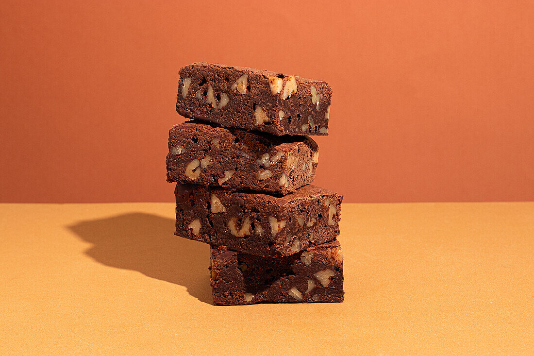 Composition of little stack of tasty sweet brownie yellow and orange background