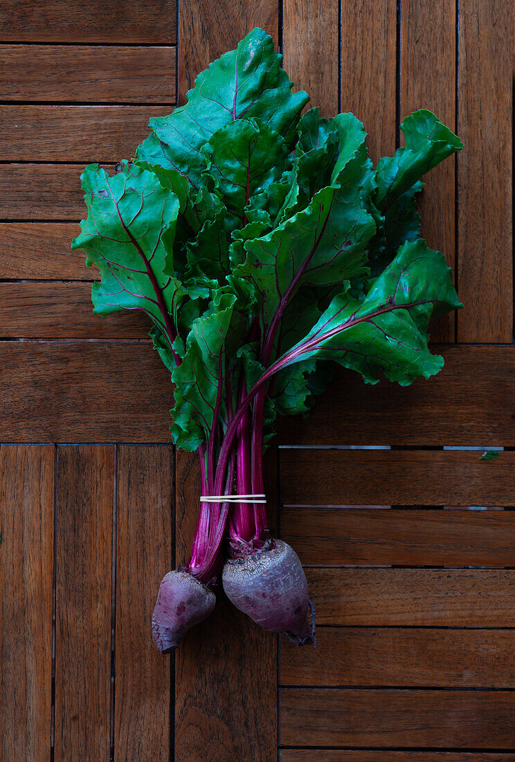 From above of bunch of beet placed on black shabby background in studio