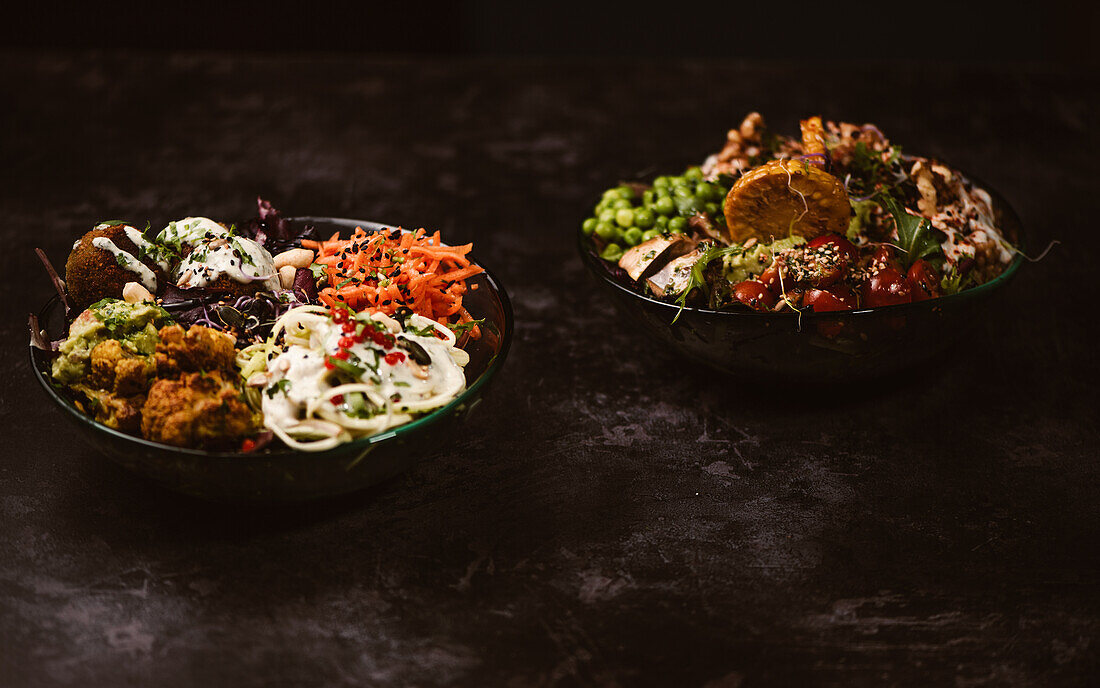 Appetitliche vegetarische Bio-Gerichte mit verschiedenen Gemüsesorten auf einem rustikalen dunklen Tisch