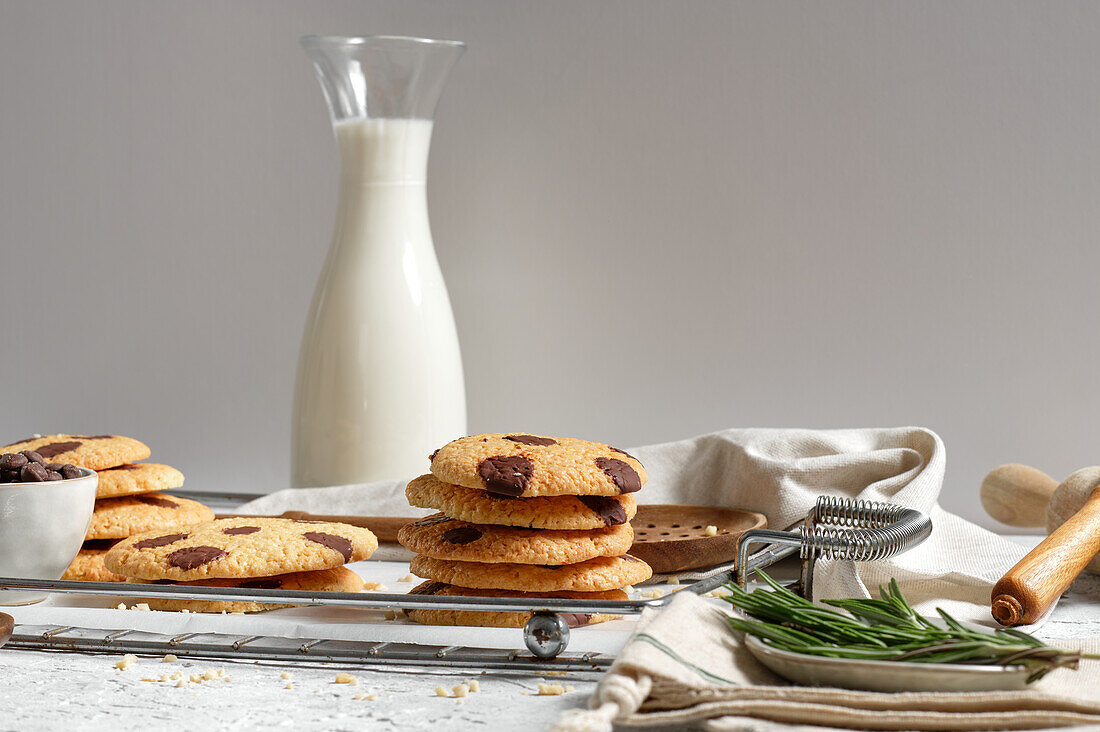 Delicious homemade sweet cookies with chocolate ships served on tray with glass jar of milk