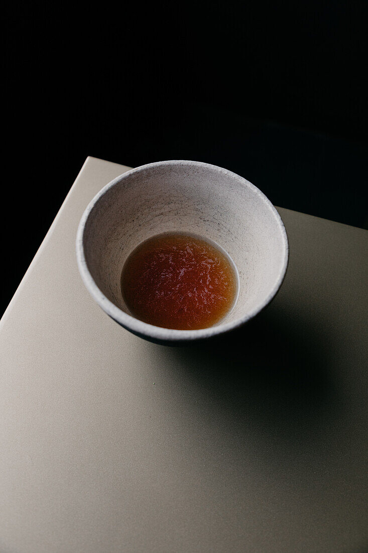 From above of porcelain bowl with soy sauce in restaurant