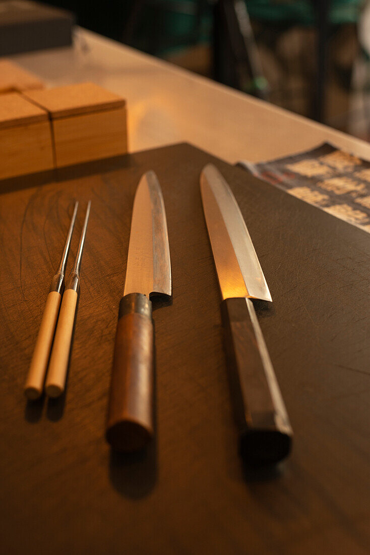 Sharp knives placed on wooden table in Asian restaurant
