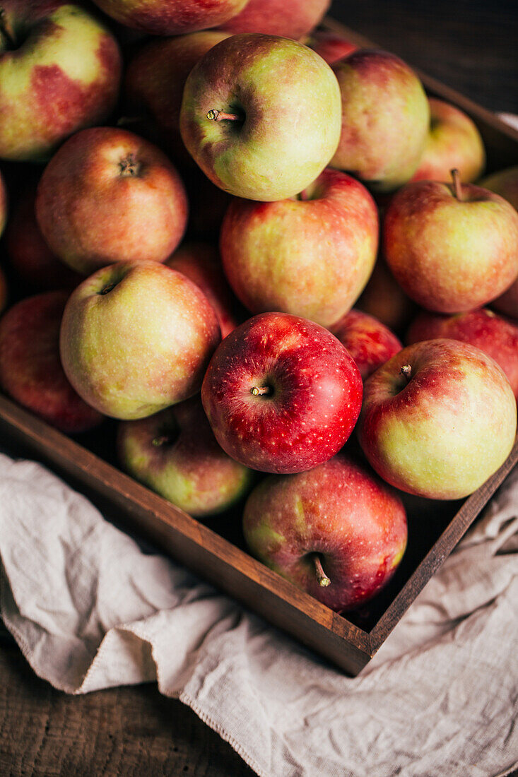 Frische rote Äpfel in einer Schachtel auf einem Tisch