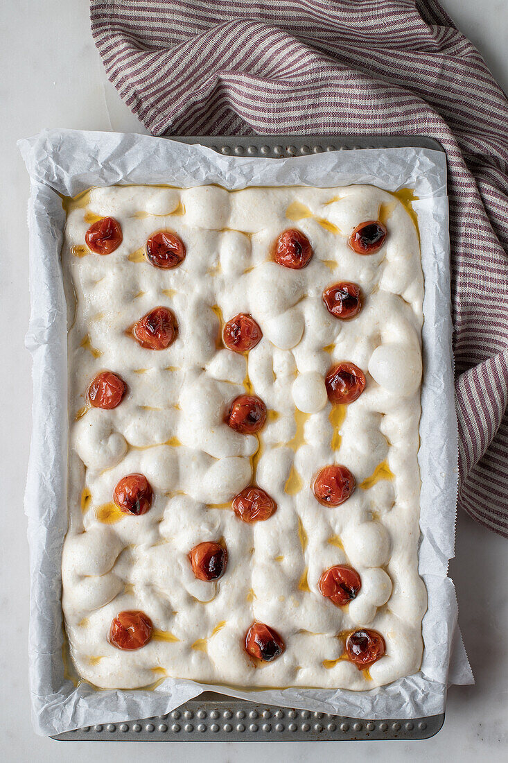 From above dough for delicious focaccia with sun dried tomatoes