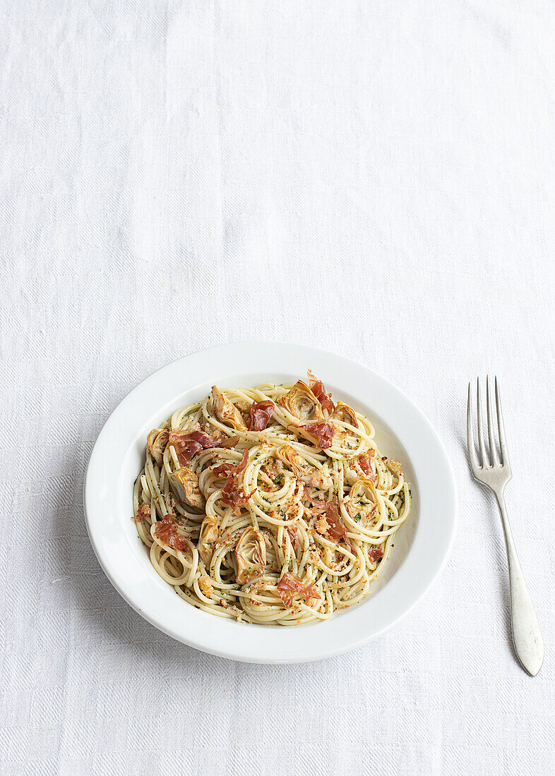 Closeup of a plate of spaghetti with artichokes seen from above