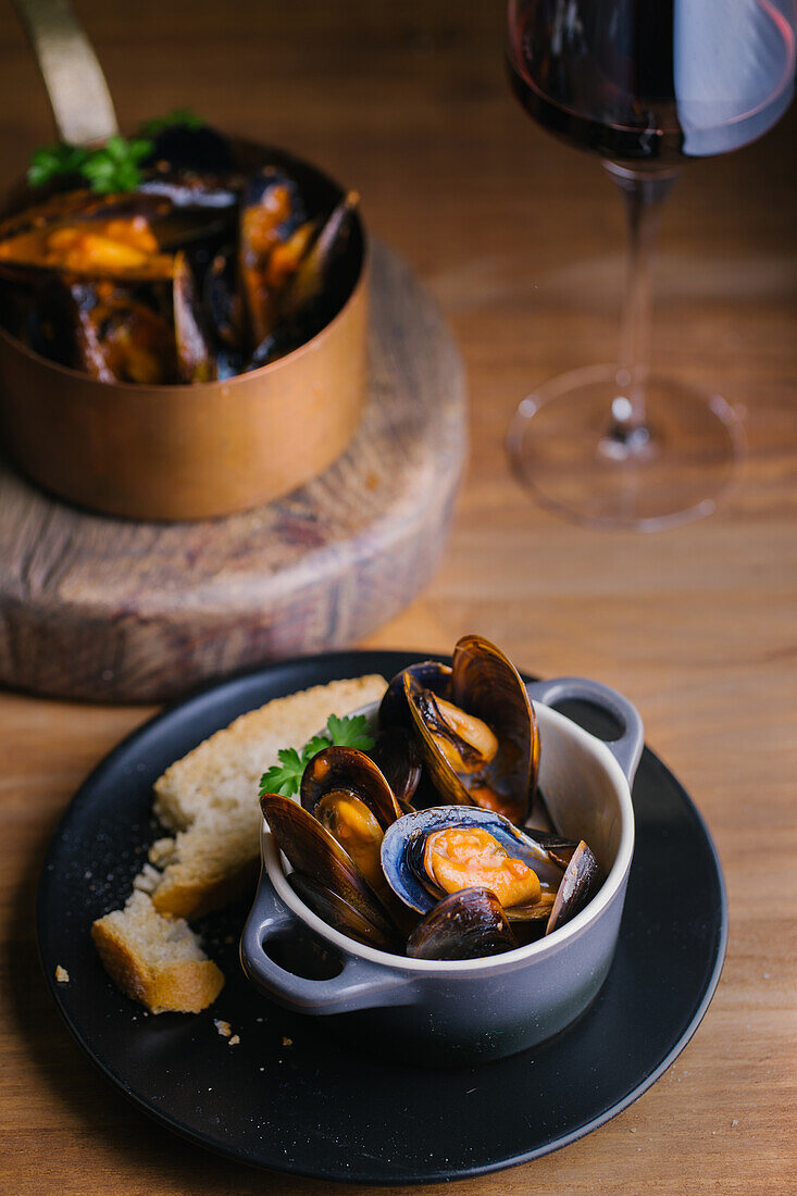 Köstliche Muscheln mit Kräutern in einem Metalltopf