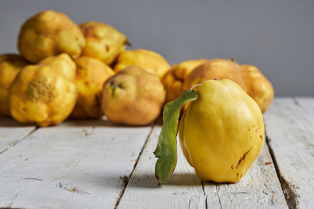 Fresh whole sour yellow lemons on white wooden background