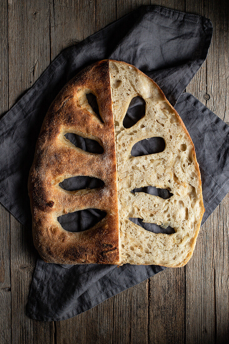 Top view of delectable loaf of bread placed on napkin on table