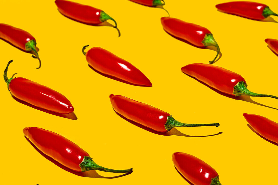 From above of fresh ripe chili peppers on yellow background