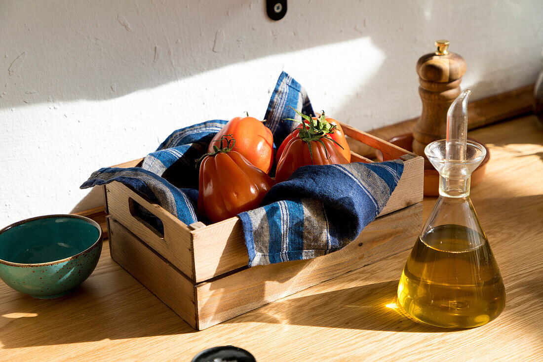 High angle of fresh ripe red tomatoes placed on natural wooden tray with napkin in home kitchen